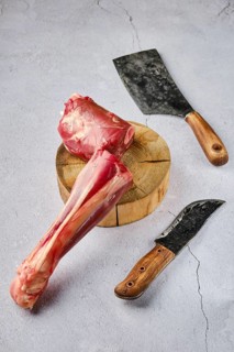 Overhead view of raw fresh deer shank with spice and herb over concrete background