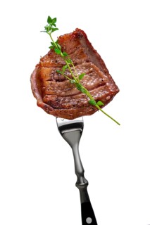 Piece of fried meat on fork isolated on white