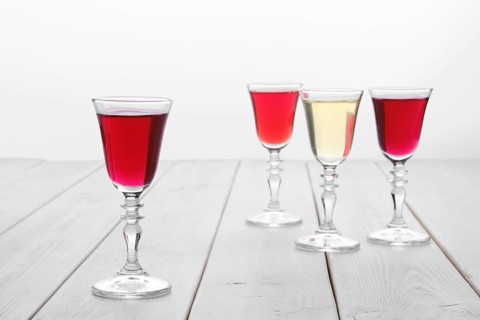 Vodka infused with berries on wooden background