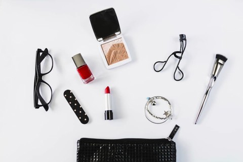Glasses cosmetics near stylish makeup bag