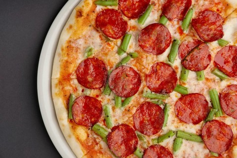 Top view of part of pizza pepperoni on black table