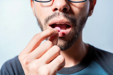 Person taking a pill isolated