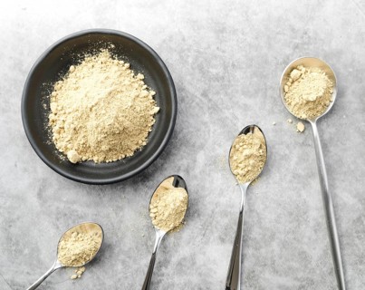 Organic food powder in bowl and spoons
