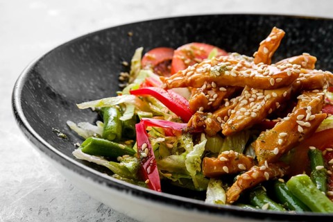 Closeup view of salad with chicken and teriyaki sauce