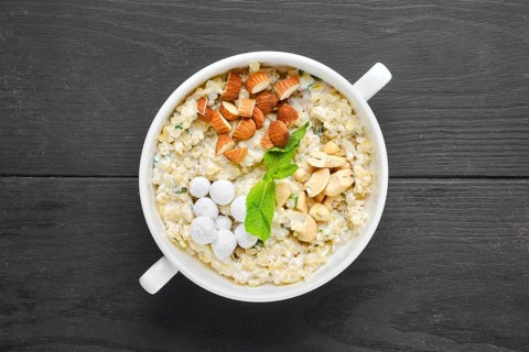 Overhead view of bulgur porridge with almond nuts and hazelnuts and cranberries in sugar pouder breading