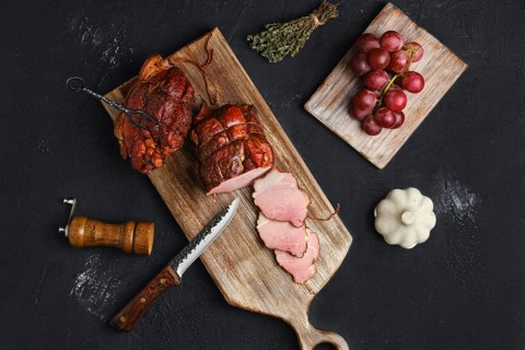 Air dried pork ham on wooden cutting board