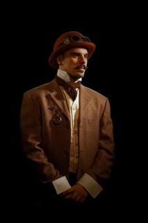 Portrait of steampunk man in hat and glasses. Photo contains strong noise due to low light and high ISO