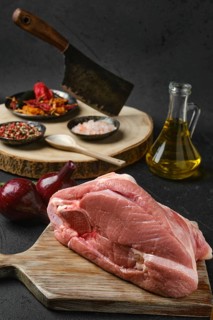 Raw slice of beef steamship round with cooking ingredients on black background