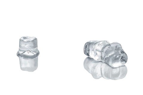 Piece of ice cubes melting on white glass table