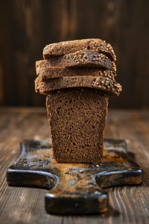 Closeup view of fresh rye brown bread on wooden cutting board