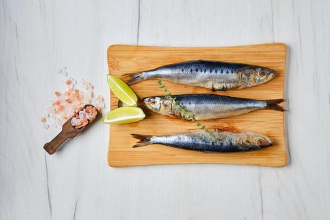 Overhead view of fresh gutted smelt on wooden cutting board