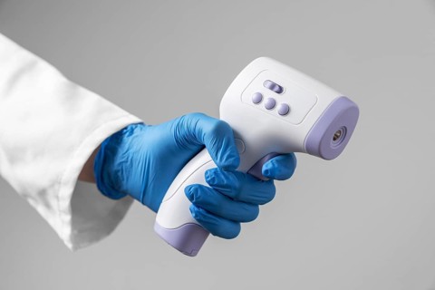 Doctor with gloves holding thermometer
