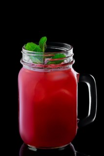 Mug with cranberry cocktail isolated on black background