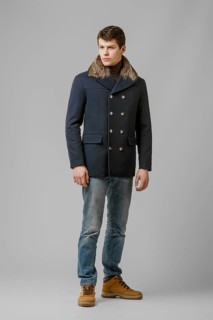Full length portrait of handsome man in warm coat with hood posing in studio