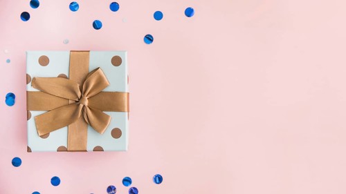 Wrapped present with brown bow and ribbon on pastel pink backdrop. Resolution and high quality beautiful photo