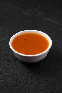 Small bowl with spicy orange sauce for poultry