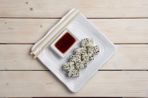Top view of plate with salmon rolls with hashi and siy sauce