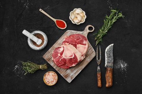 Overhead view of raw beef ossobuco steak with spices
