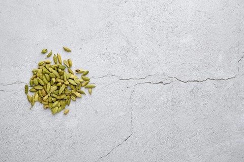 Overhead view of pile of cardamom on abstract background