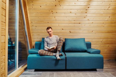 Man sits on sofa and reading a book