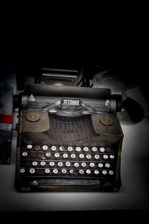 Retro syled tiny typewriter model on a white background