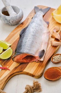 Raw fresh headless pink salmon on wooden cutting board