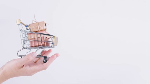 Person holding small grocery cart with gift boxes