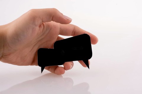 Hand holding dialogue boxes on a white background