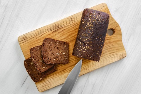 Top view of loaf of brown sourdough bread with sunflower seeds and sesame