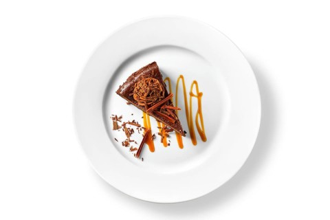 Overhead view of chocolate cake with caramel sauce isolated on white