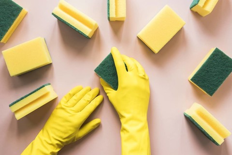 Close up person with yellow gloves sponges