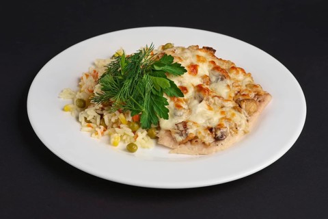 Chicken fillet with mushrooms and cheese garnished with rice
