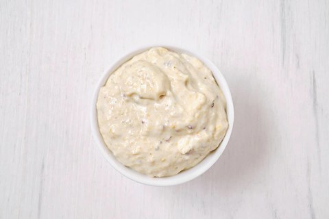 Overhead view of small bowl with caesar sauce for salad