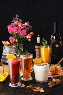 Composition with herbal and fruit hot alcohol drinks with ingredients on the table