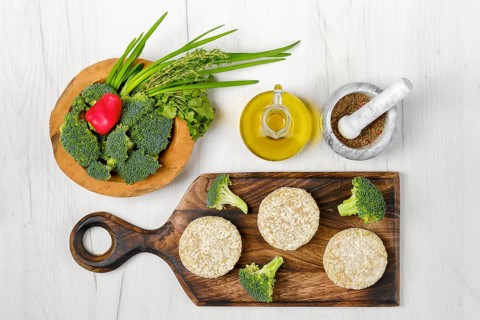 Top view of semifinished homemade chicken cutlet with broccoli on a wooden serving board