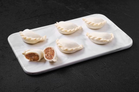 Frozen dumplings stuffed with beef meat and provencal herbs on marble serving plate
