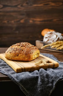 Fresh oats bread with sunflower seeds and sesame on wooden table