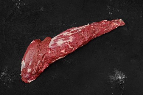 Overhead view of raw beef tri-tip loin on black background