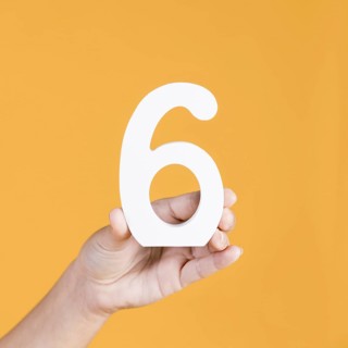 Close up hand holding number 6