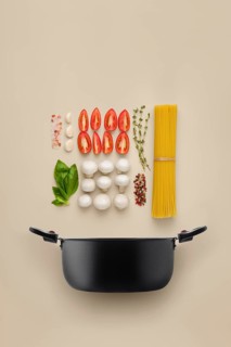 Recipe of spaghetti pasta organized into component parts over solid background