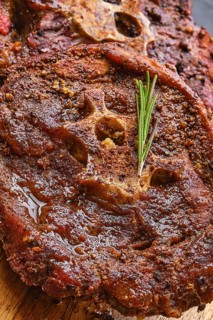 Macro photo of grilled lamb neck on wooden cutting board
