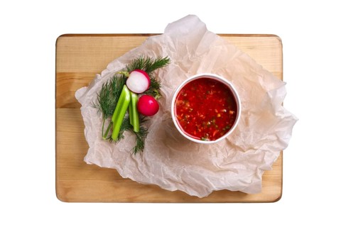 Top view of plate with celery and radish soup isolated on white