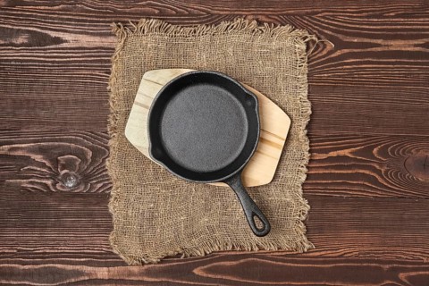 Empty mini cast-iron skillets on wooden table