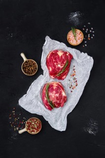 Fresh raw lamb neck on wrapping paper with herbs and seasoning