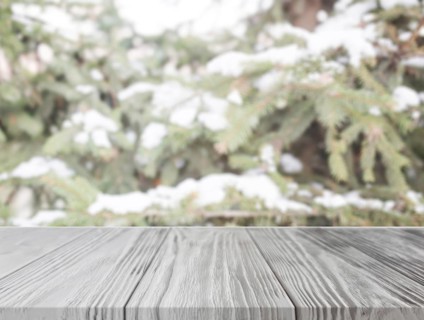Empty wooden table front christmas tree with snow