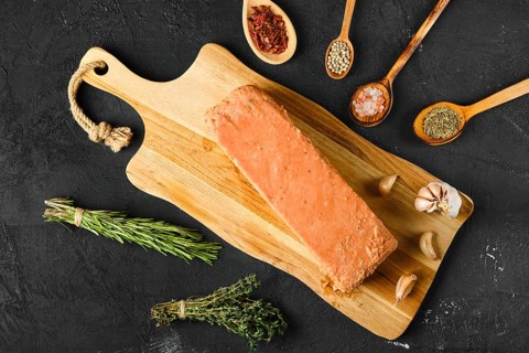 Overhead view of raw pieces of salmon pressed in briquette with spice and herbs