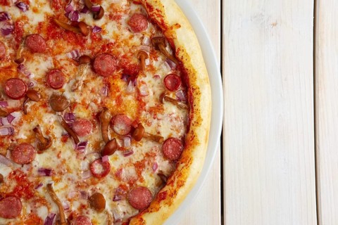 Top view of pizza with sausage and honey agaric