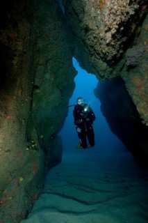 Natural tunnel in lava reef formed after primeval volcanic eruption