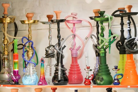 Group of eastern hookahs placed of various colors on a shelf