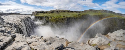 Canyon with falling water masses and rainbow